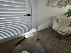 Mold inspection in Coto de Caza bedroom with carpet pulled back near baseboard.