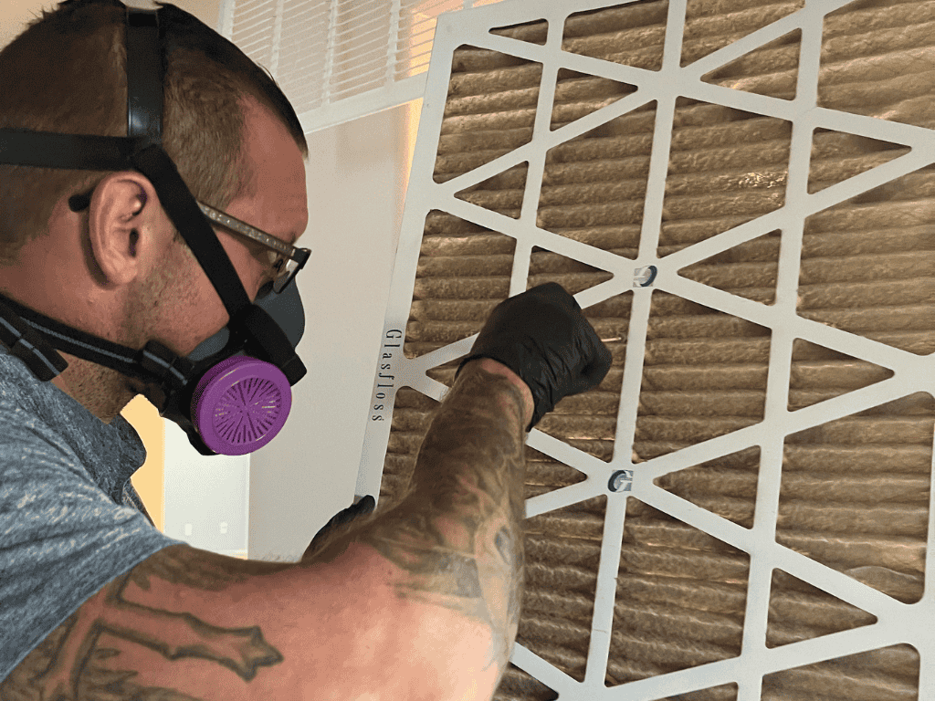 Mold Inspector Wearing Protective Mask Examining Hvac Air Filter For Contamination.