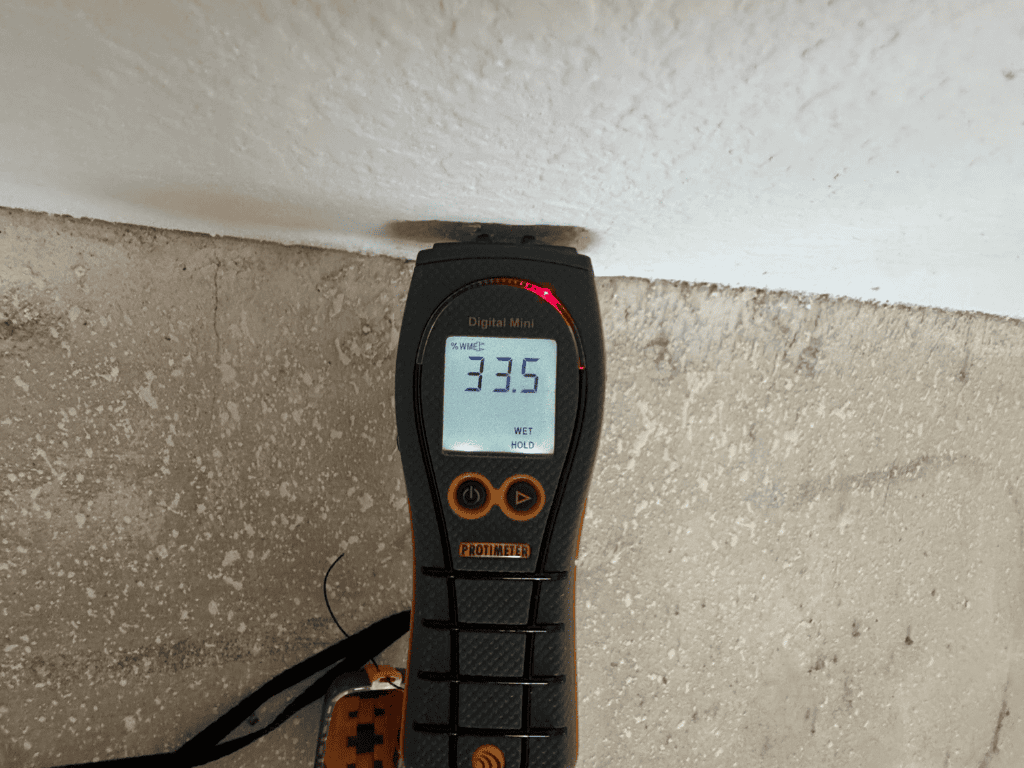 Digital Moisture Meter Showing Elevated Wall Moisture Level During Home Inspection.