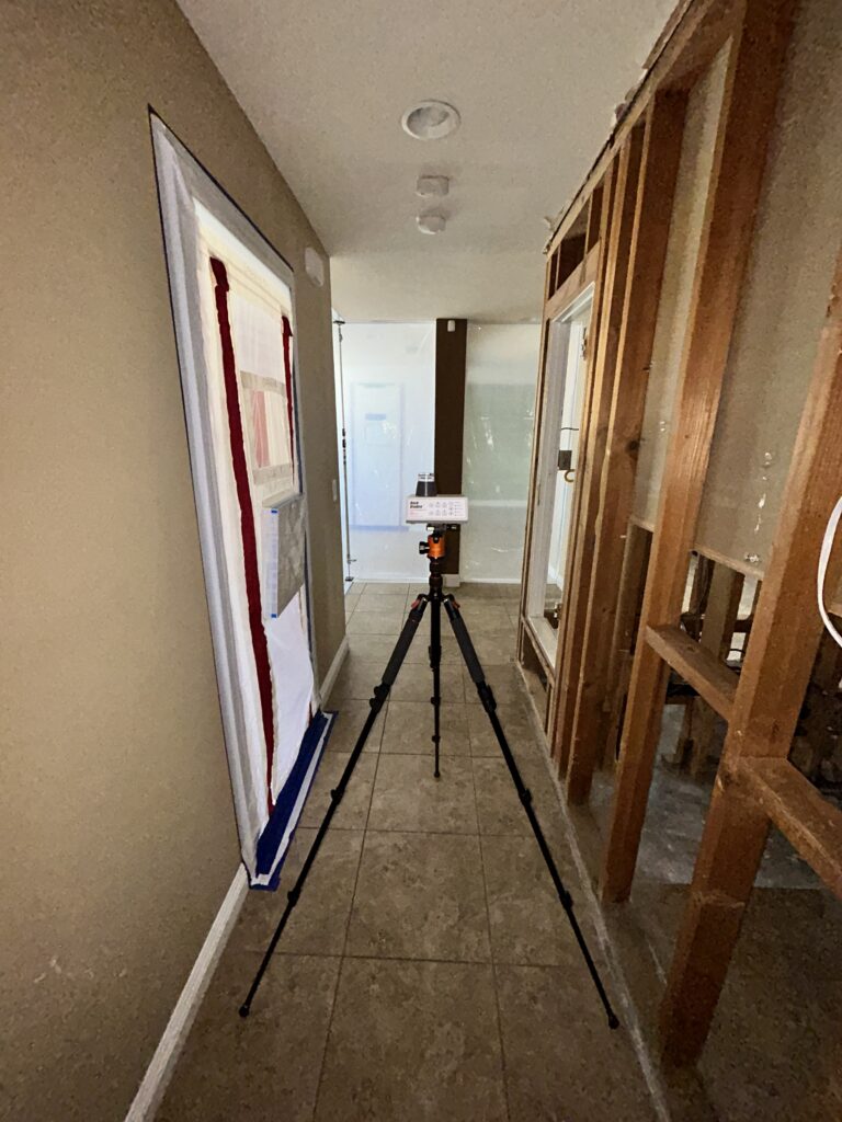 Mold Clearance Inspection Equipment Set Up In A Hallway Of A Brea Home, With Exposed Framing And Plastic Sheeting, During A Post-Remediation Inspection To Verify Mold-Free Conditions