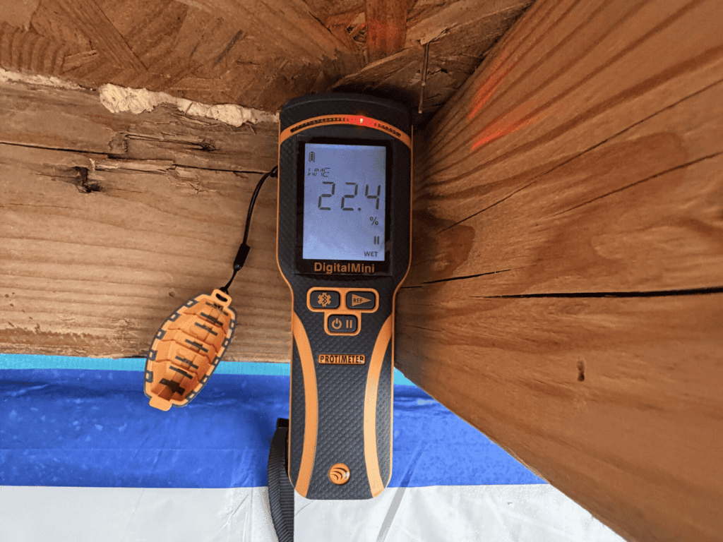 Moisture Meter Measuring Wood Moisture Levels During Mold Inspection