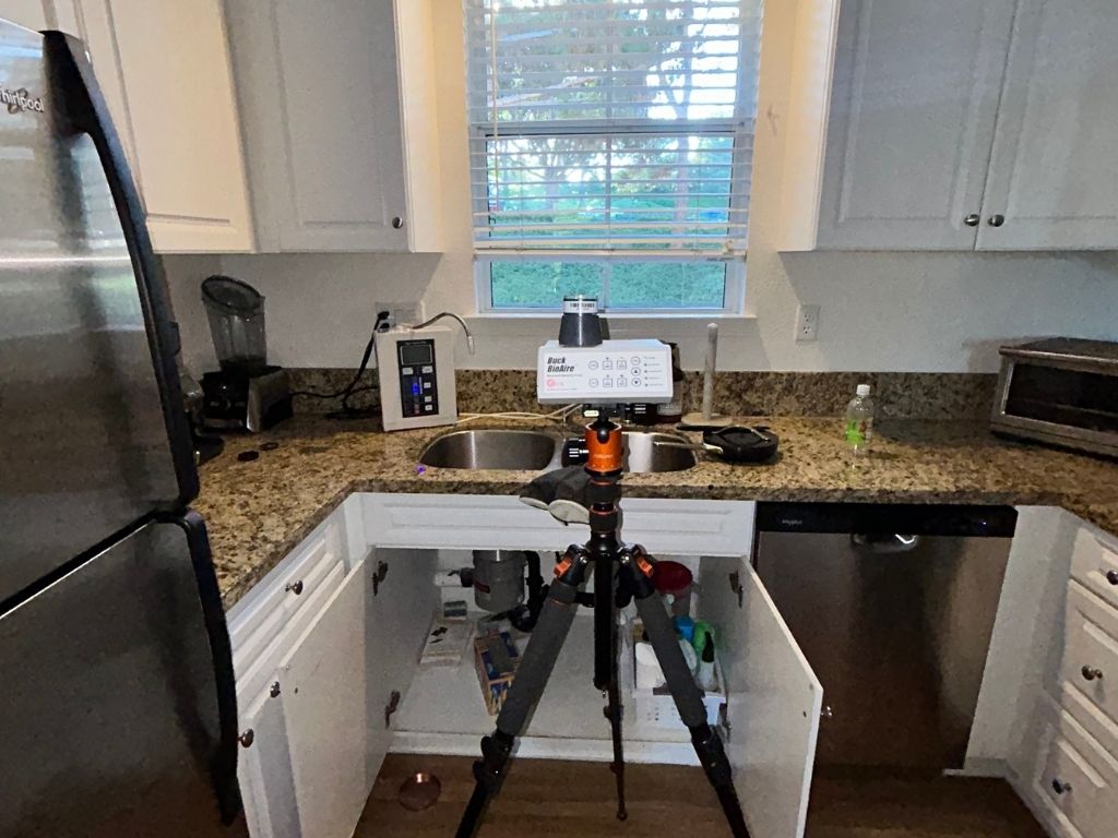 Mold Air Quality Testing Equipment Set Up In A Residential Kitchen Near Sink And Cabinets To Detect Indoor Air Contamination