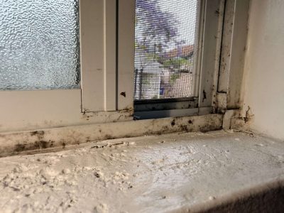 Window sill and frame with heavy black mold growth along the seals, found during a certified GPMI mold inspection in Orange County.